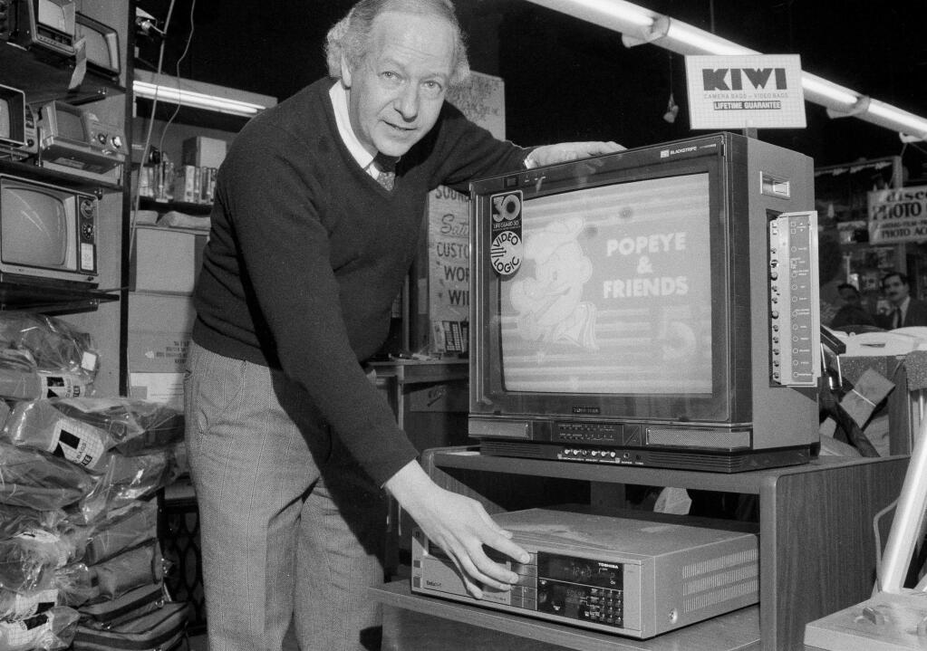 FILE - In this Jan. 17, 1984, file photo, Mel Tillman, manager of S&S Sound City, in New York, demonstrates how a television program is taped with a Toshiba video cassette recorder. Japanese electronics maker Funai Electric Co. says it's yanking the plug on the world's last video cassette recorder. A company spokesman, who requested anonymity citing company practice, confirmed Monday, July 25, 2016, that production will end sometime during the month, although he would not give a date. (AP Photo/Suzanne Vlamis, File)