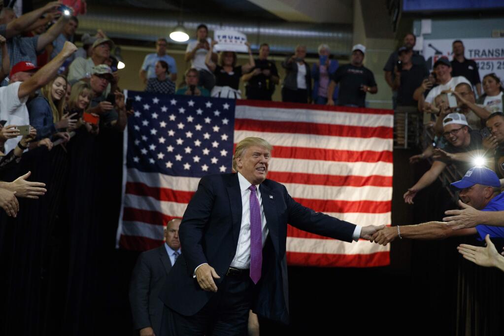 Republican presidential candidate Donald Trump shakes hands as he arrives to a campaign rally at Xfinity Arena of Everett, Tuesday, Aug. 30, 2016, in Everett, Wash. (AP Photo/Evan Vucci)