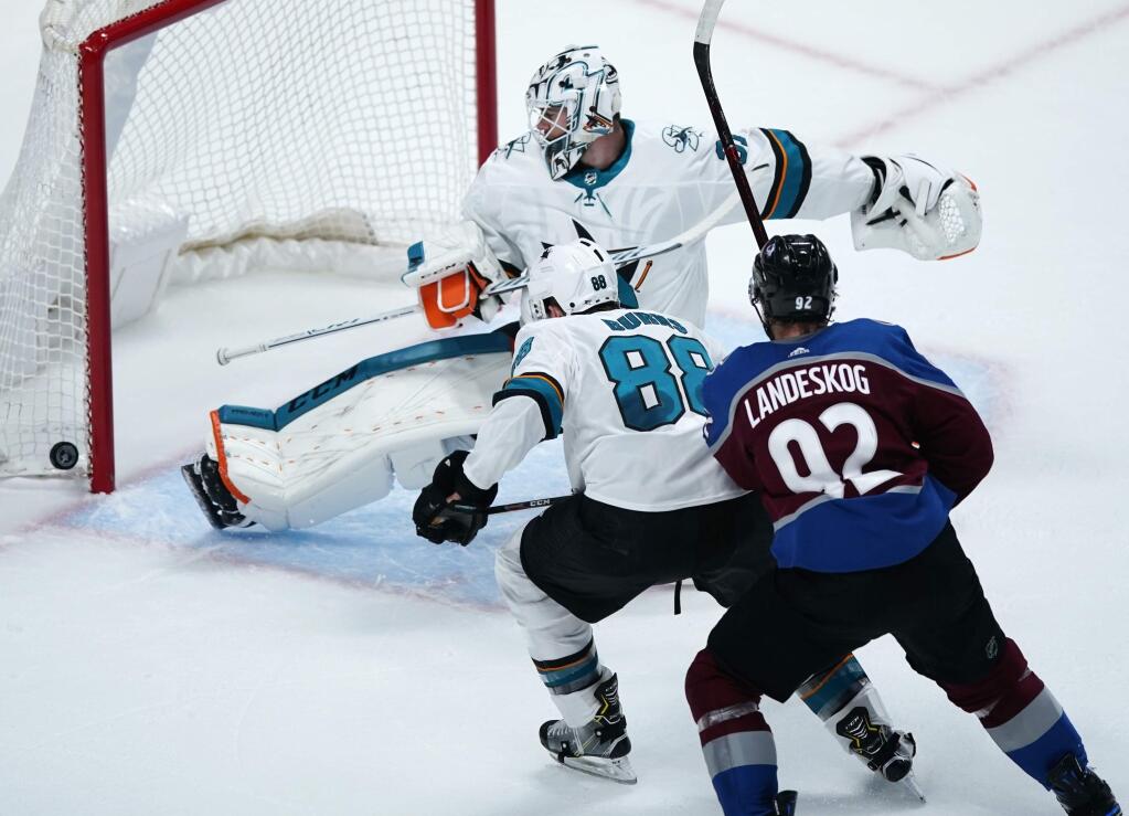 The San Jose Sharks goaltender Martin Jones, back, makes a kick-save of a shot as defenseman Brent Burns, center, and Colorado Avalanche left wing Gabriel Landeskog pursue the puck in the first period of Game 6 of asecond-round playoff series Monday, May 6, 2019, in Denver. (AP Photo/Jack Dempsey)