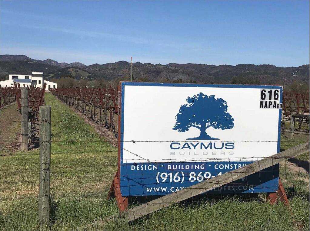 Exhibit 2 in Caymus Vineyard's suit against Caymus Builders et al: a sign for the Sonoma-based construction company posted in a vineyard, after the recent fires. This photograph was taken on Napa Rd. in Sonoma, signalling a building project. (Caymus Vineyards)