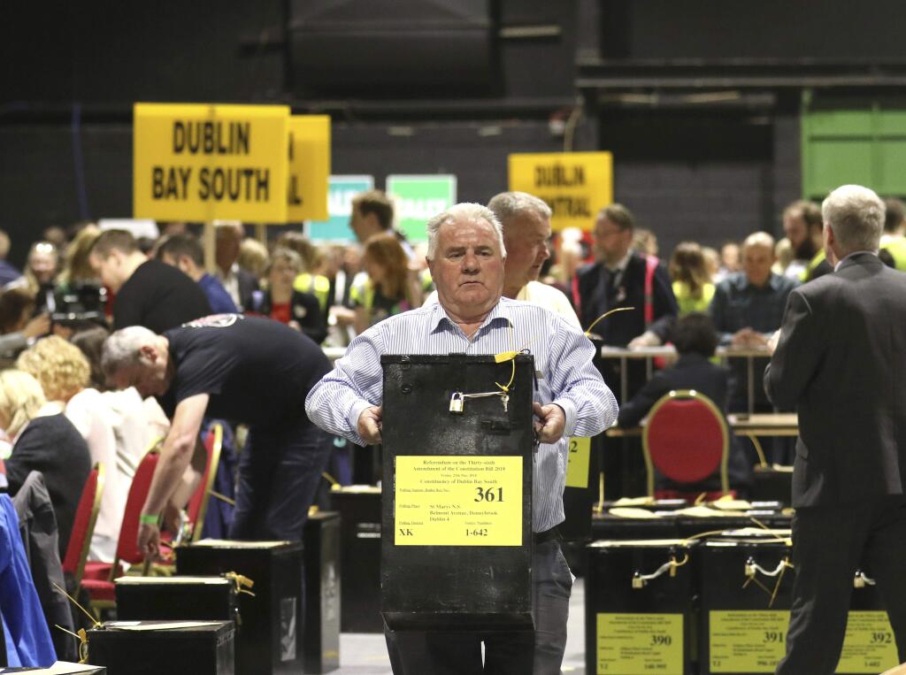 A man carries a ballot box as counting of votes begins in the Irish referendum on the 8th Amendment of the Irish Constitution, in Dublin, Ireland, Saturday, May 26, 2018. Official counting began Saturday in Ireland's historic abortion rights referendum, with two exit polls predicting an overwhelming victory for those seeking to end the country's strict ban. (AP Photo/Peter Morrison)