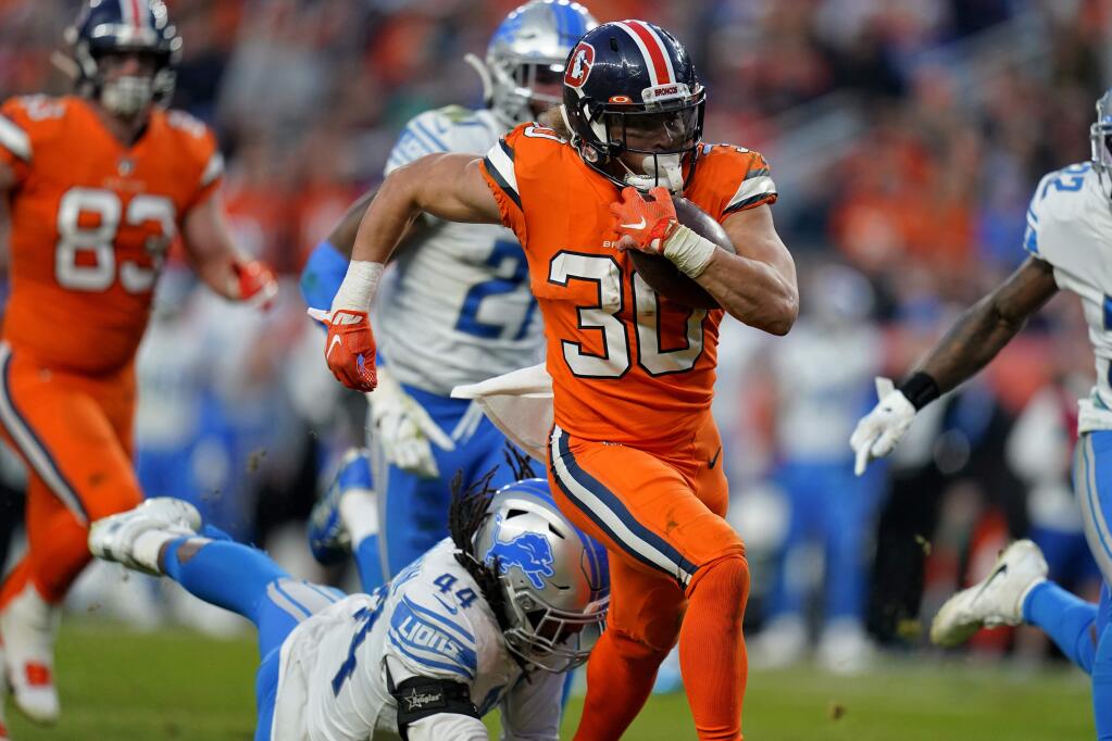 Denver Broncos running back Phillip Lindsay (30) breaks free from the grasp of Detroit Lions linebacker Jalen Reeves-Maybin (44) for a touchdown during the second half of an NFL football game, Sunday, Dec. 22, 2019, in Denver. (AP Photo/Jack Dempsey)