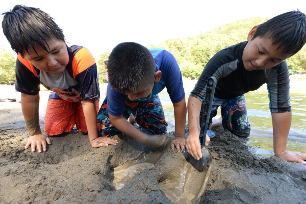 From left, Oscar Vidrio, 10, Amadeo Vidrio, 11, and Luis Vidrio, 9, of Rohnert Park play with wet sand at the Spring Lake swimming lagoon in Santa Rosa on Sunday, June 18, 2017. (ERIK CASTRO/ FOR THE PD)