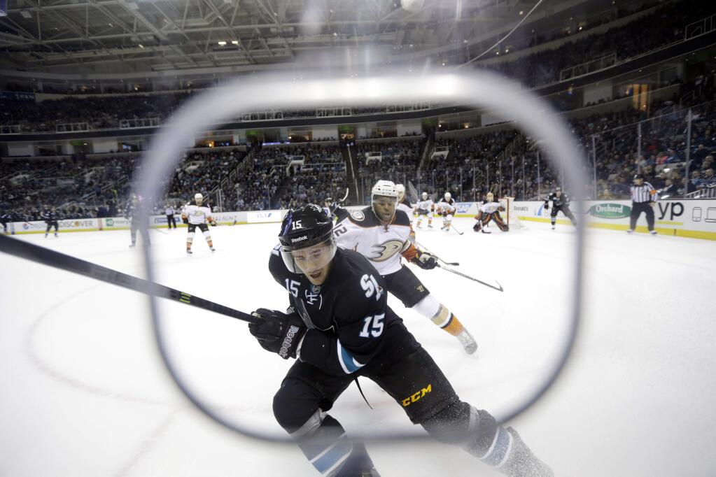 San Jose Sharks' James Sheppard (15) reaches for the puck against the boards in front of Anaheim Ducks' Devante Smith-Pelly (12) during the first period of a game Thursday, Jan. 29, 2015, in San Jose. (AP Photo/Marcio Jose Sanchez)