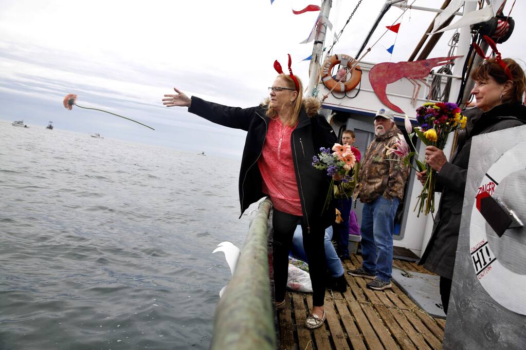 Karla Baiocchi throws flowers into the water during the Blessing of the Fleet as part of the Bodega Bay Fisherman's Festival on Sunday, April 10, 2016 in Bodega Bay, California . (BETH SCHLANKER/ The Press Democrat)