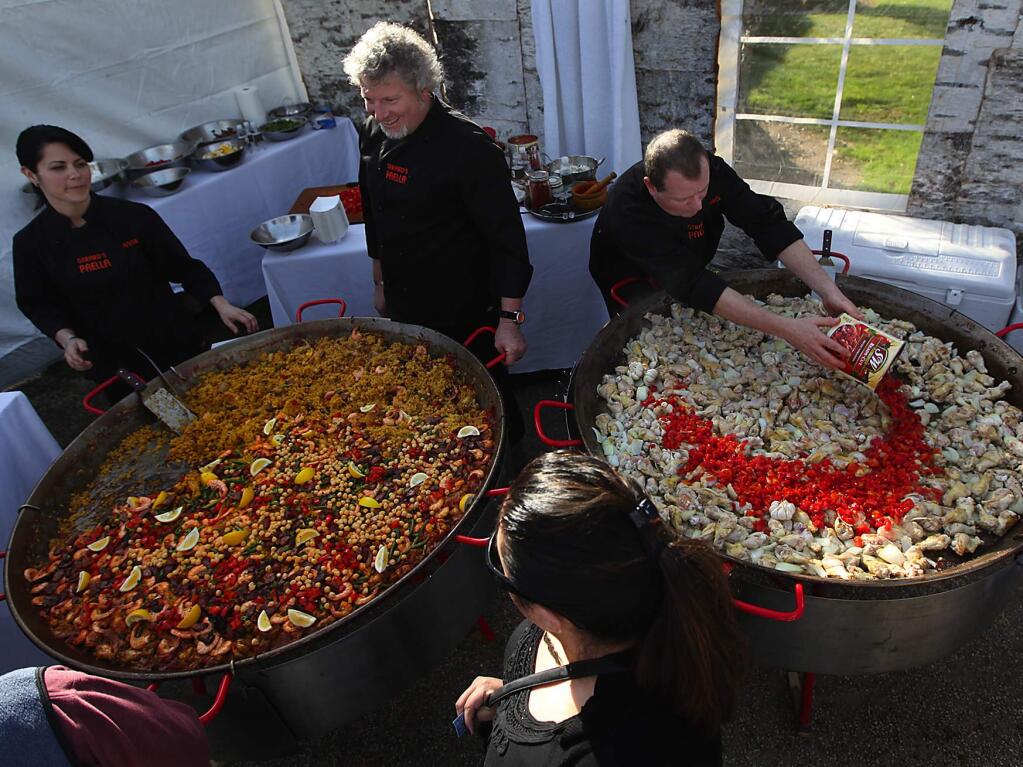 At Bella Vineyards and Wine Caves in west Dry Creek, Gerard Nebesky of Gerard's Paella, middle, with Anna Ming, left and Chris Hataway, cook up a mess of chicken and shrimp paella during Winter Wineland, Saturday Jan. 15, 2011. Kent Porter / Press Democrat) 2011