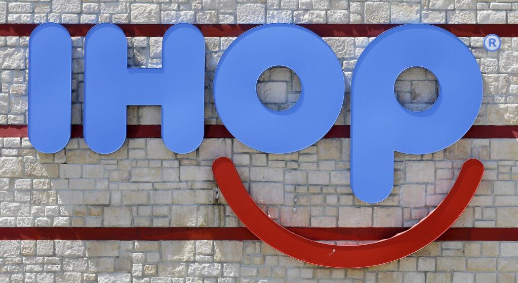 FILE - This May 11, 2017, file photo shows an IHOP sign at a restaurant in Hialeah, Fla. On Monday, July 9, 2018, it was back on social media, this time to promote a pancake deal tied to IHOP's 60th birthday. On Twitter, the company said, “That's right, IHOP! We'd never turn our back on pancakes (except for that time we faked it to promote our new burgers).” The company had started using the IHOb name on social media, its website and for in-store promotions to draw attention to a new line of burgers made of Black Angus ground beef. (AP Photo/Alan Diaz, File)