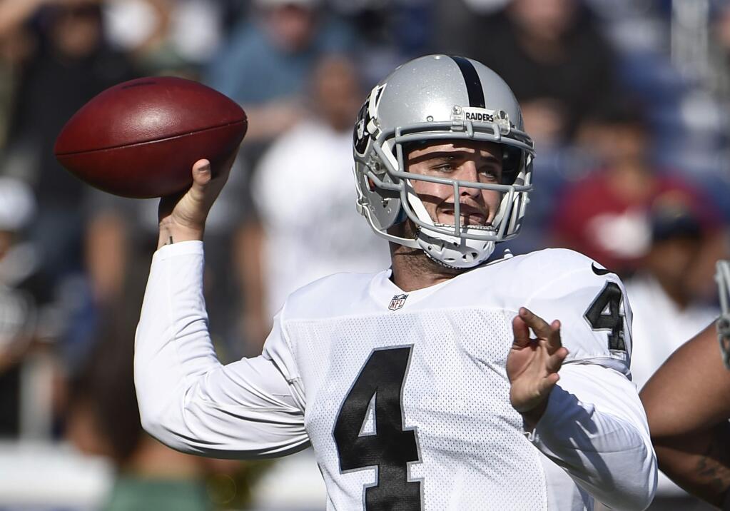 Oakland Raiders quarterback Derek Carr aims a pass against the San Diego Chargers during the first half of an NFL football game Sunday, Nov. 16, 2014, in San Diego. (AP Photo/Denis Poroy