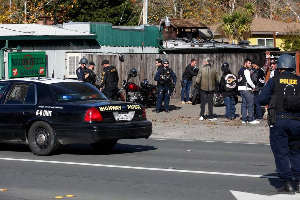 Law enforcement officers from various agencies search motorcycles outside the Wagon Wheel Saloon in Santa Rosa, California on Saturday, November 18, 2017. (Alvin Jornada / The Press Democrat)