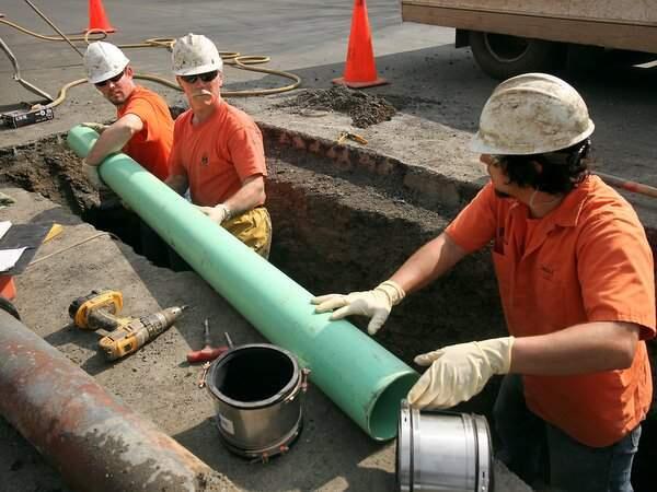 Santa Rosa maintenance workers Mike Simi, Terry Finigan and Armagh Oceguera install a vinyl sewer line on Yardley Avenue. (FILE)
