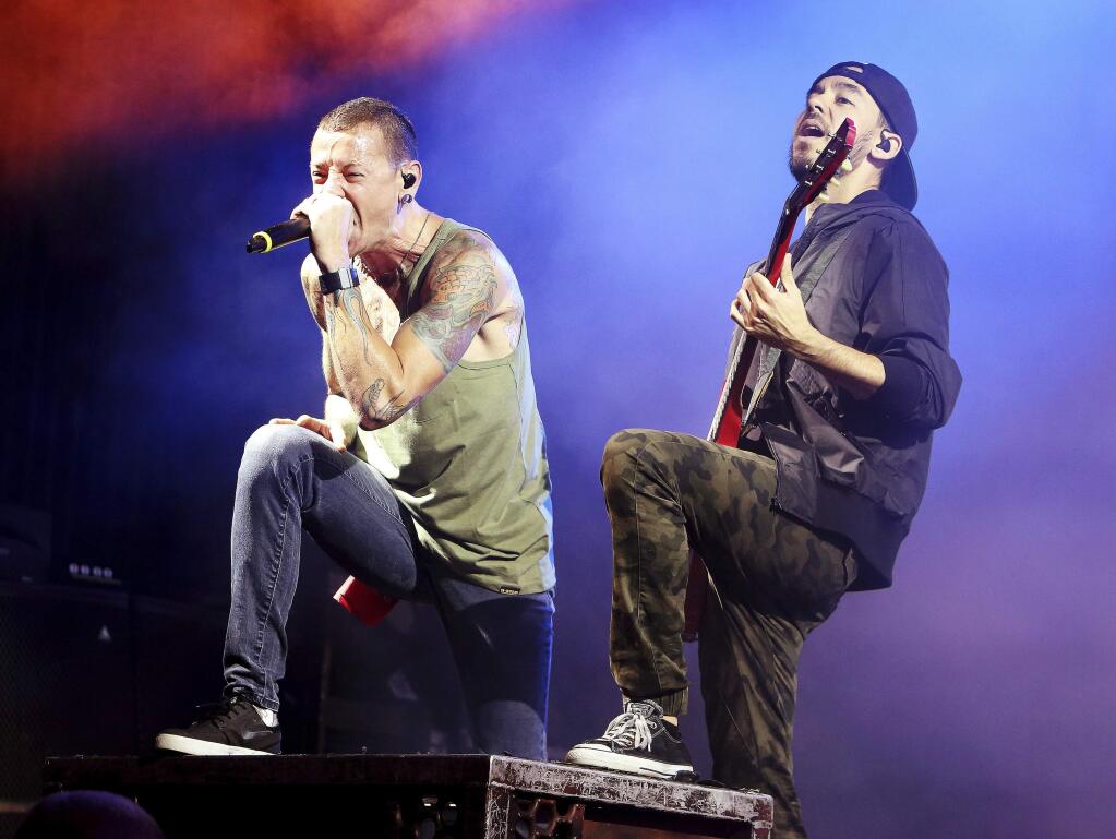 FILE - In this Aug. 15, 2014, file photo, Chester Bennington, left, and Mike Shinoda of the band Linkin Park perform in concert during their 'Carnivores Tour 2014' at the Susquehanna Bank Center in Camden, N.J. Billboard said July 23, 2017, that the band's albums have returned to its album charts following Bennington's July 21 death. (Photo by Owen Sweeney/Invision/AP, File)