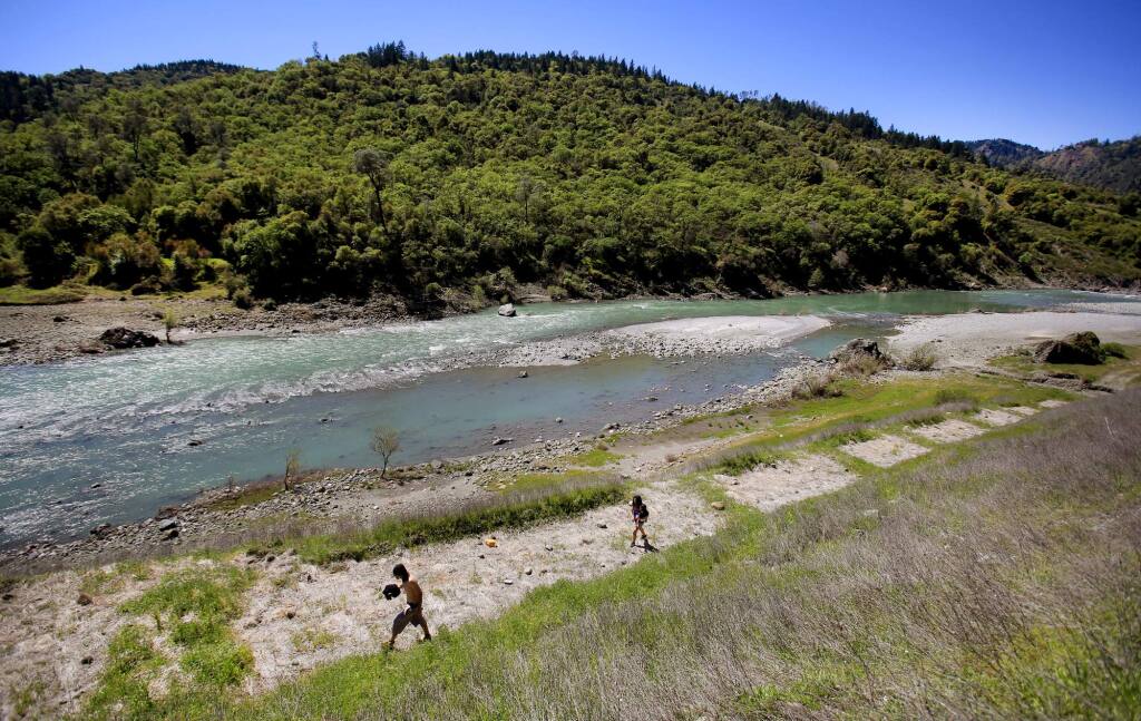Chris Blazer, left and Melissa Garcia of San Francisco, head back to their vehicle after a day of sunning along the banks of the Eel River in Dos Rios on Wednesday, April 7, 2016. (KENT PORTER/ PD FILE)