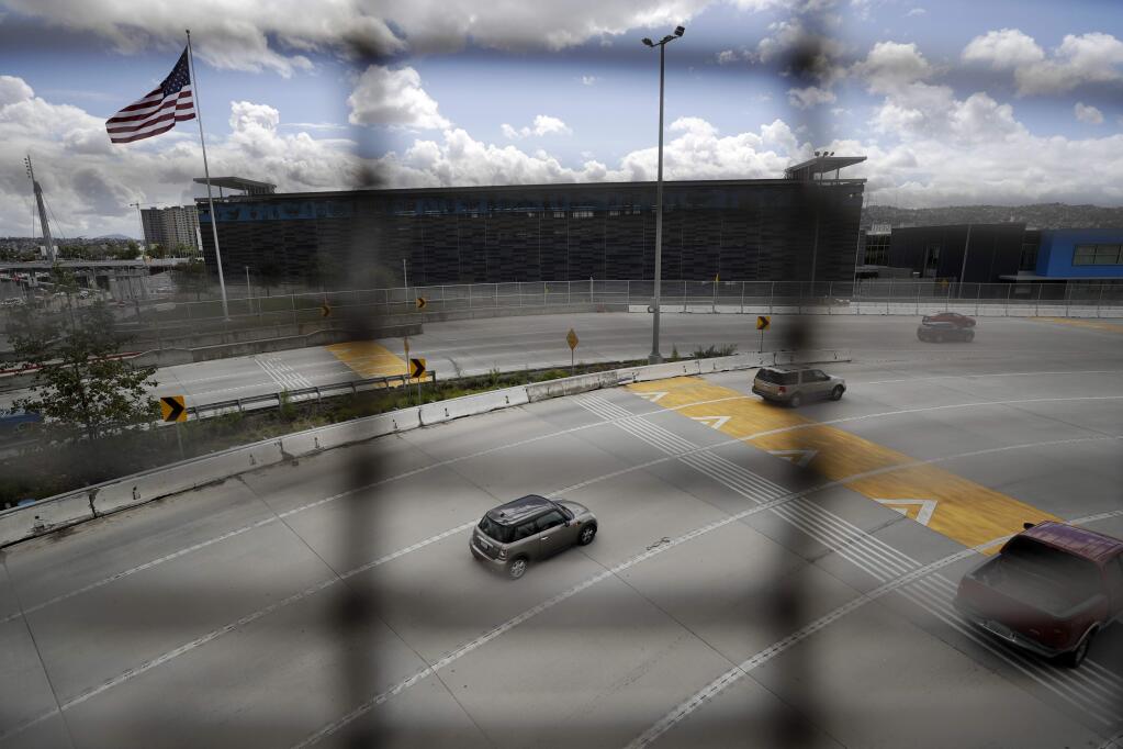 A few cars head south to cross from San Diego into Tijuana, Mexico, through what is normally one of the world's busiest land border crossings, Thursday, March 19, 2020, in San Diego. (AP Photo/Gregory Bull)