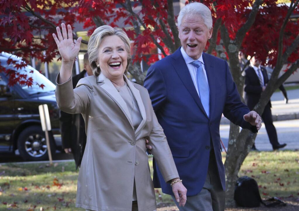 FILE - In this Nov. 8, 2016, file photo, then-Democratic presidential candidate Hillary Clinton, and her husband former President Bill Clinton, greet supporters after voting in Chappaqua, N.Y. (AP Photo/Seth Wenig, File)