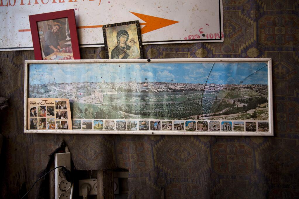 A framed photo of Jerusalem's old city hangs in a juice stand, in Jerusalem old city, Tuesday, Dec. 5, 2017. U.S. officials have said he may recognize Jerusalem as Israel's capital this week as a way to offset his likely decision to delay his campaign promise of moving the U.S. Embassy there. Trump's point-man on the Middle East, son-in-law Jared Kushner, later said the president hasn't decided yet what steps to take. (AP Photo/Oded Balilty)