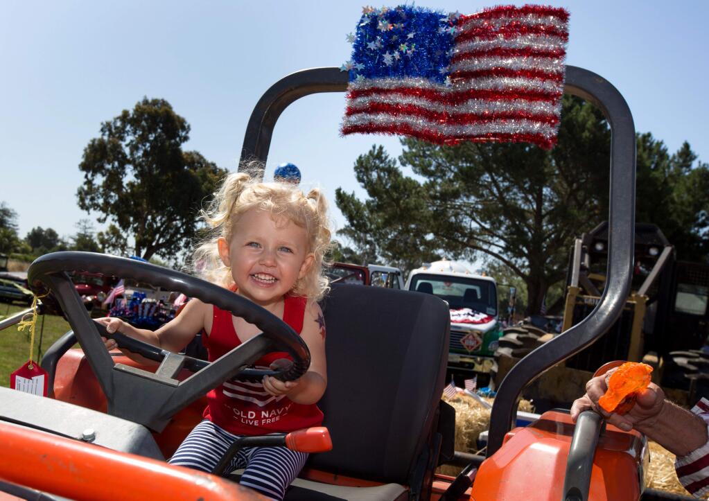 Cora Veath, 2, of Leesburg, Virginia, sits at the steering wheel as her grandparents (Gary Collins and Nancy Corda of Petaluma) wait to start the 41st  annual Penngrove Parade, in Penngrove, Calif., on Sunday, July 2, 2017. (Photo by Darryl Bush / For The Press Democrat)