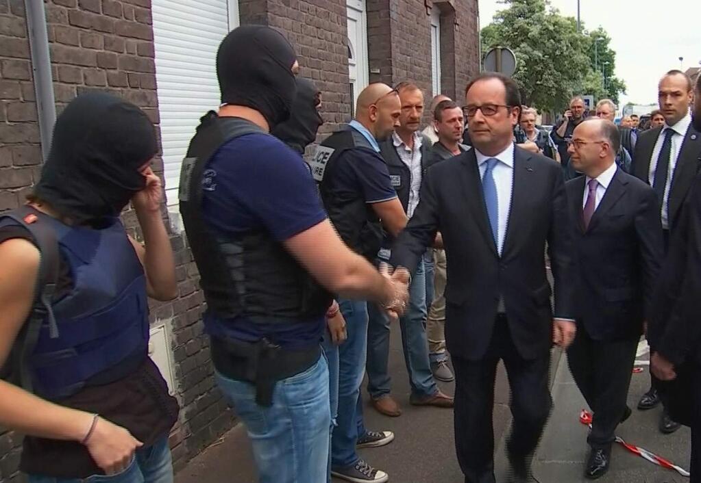 In this grab made from video, French President Francois Hollande shakes hands with police and security services personnel after arriving at the scene of the hostage situation in Saint-Etienne-du-Rouvray Normandy, France, Tuesday, July 26, 2016. (France Pool via AP)