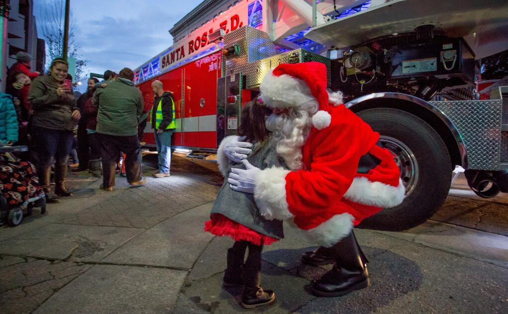 Santa greets a child during while paying visiting downtown Santa Rosa's annual Winter Lights tree lighting event in 2016. This year's event is on Friday, Nov. 24, 2017. (Jeremy Portje / For The Press Democrat)