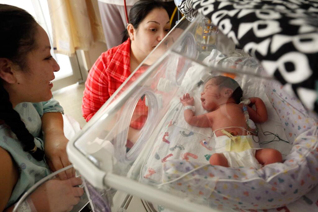 Newborn Marvella Soltero Vazquez, was born at 12:51 a.m. on New Years Day in 2016. Here she is surrounded by her mother Karla Vazquez, left, and aunt Brenda Vazquez at Sutter Santa Rosa Regional Hospital. (Alvin Jornada / The Press Democrat)
