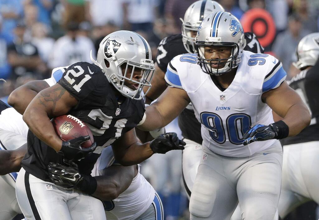 Oakland Raiders running back Maurice Jones-Drew (21) runs against Detroit Lions defensive tackle Ndamukong Suh (90) during the first half of an NFL preseason football game in Oakland, Friday, Aug. 15, 2014. (AP Photo/Marcio Jose Sanchez)