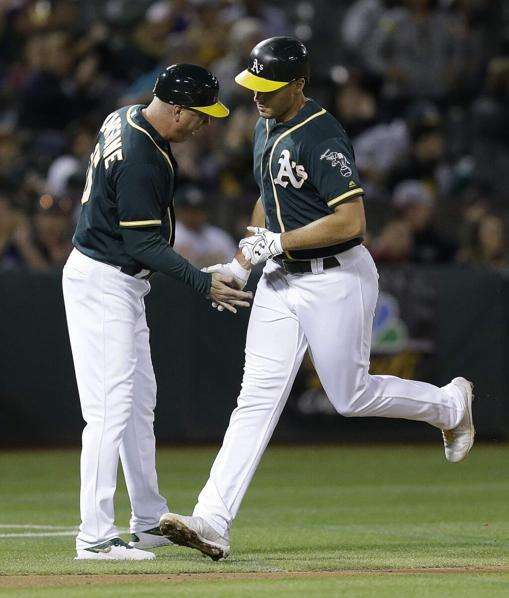 Oakland Athletics' Matt Olson, right, celebrates with third base coach Steve Scarsone after hitting a two run home run off Texas Rangers' Nick Martinez in the second inning of a baseball game Friday, Sept. 22, 2017, in Oakland, Calif. (AP Photo/Ben Margot)