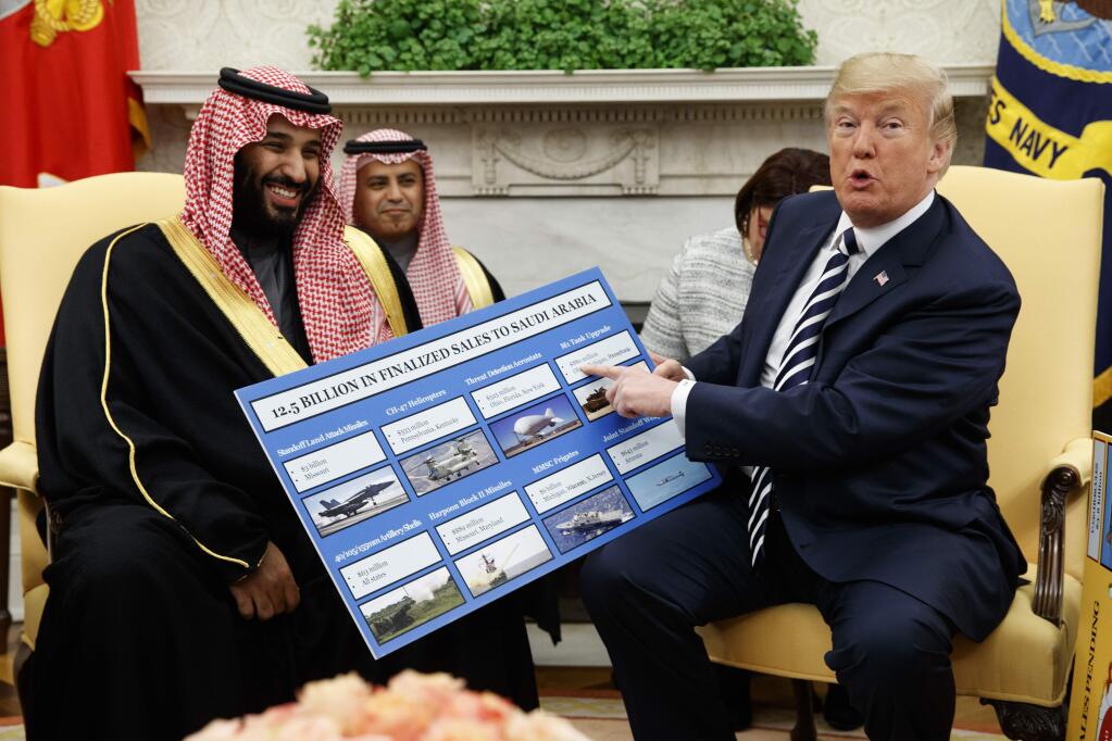 FILE - In this Tuesday, March 20, 2018 file photo, President Donald Trump holds a chart highlighting arms sales to Saudi Arabia during a meeting with Saudi Crown Prince Mohammed bin Salman in the Oval Office of the White House in Washington. (AP Photo/Evan Vucci)