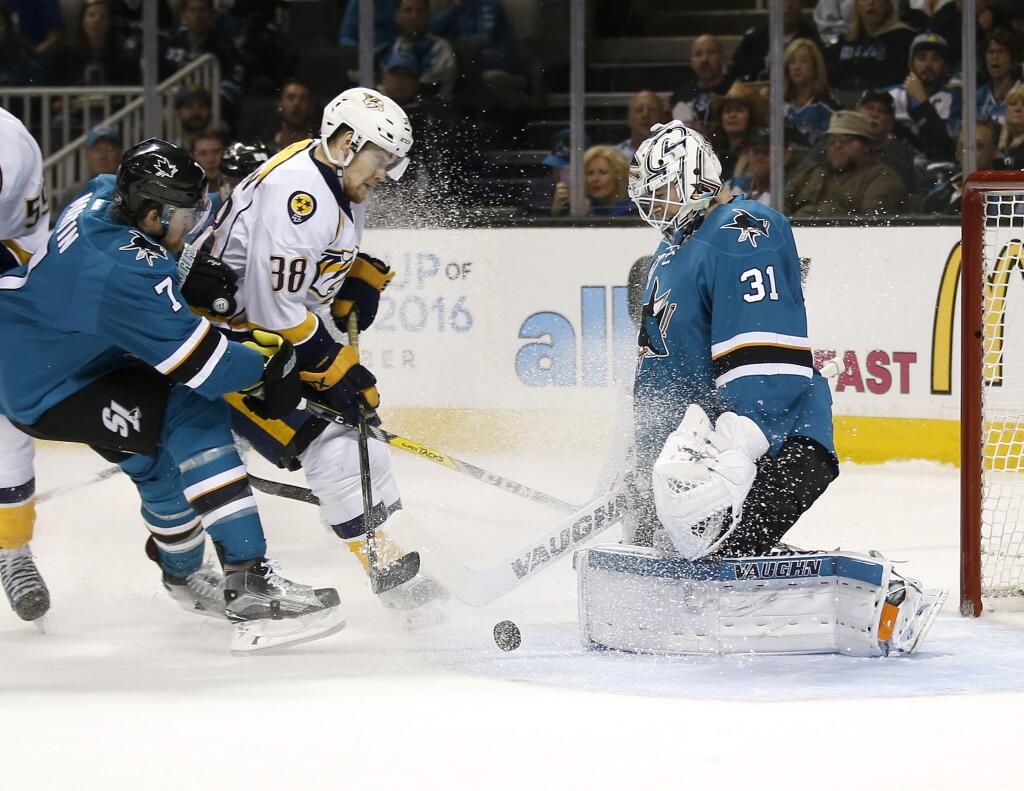 San Jose Sharks goalie Martin Jones (31) stops a shot by Nashville Predators right wing Viktor Arvidsson (38) as San Jose Sharks defenseman Paul Martin (7) defends during the second period of Game 2 in an NHL hockey Western Conference semifinal series Sunday, May 1, 2016, in San Jose, Calif. (AP Photo/Tony Avelar)