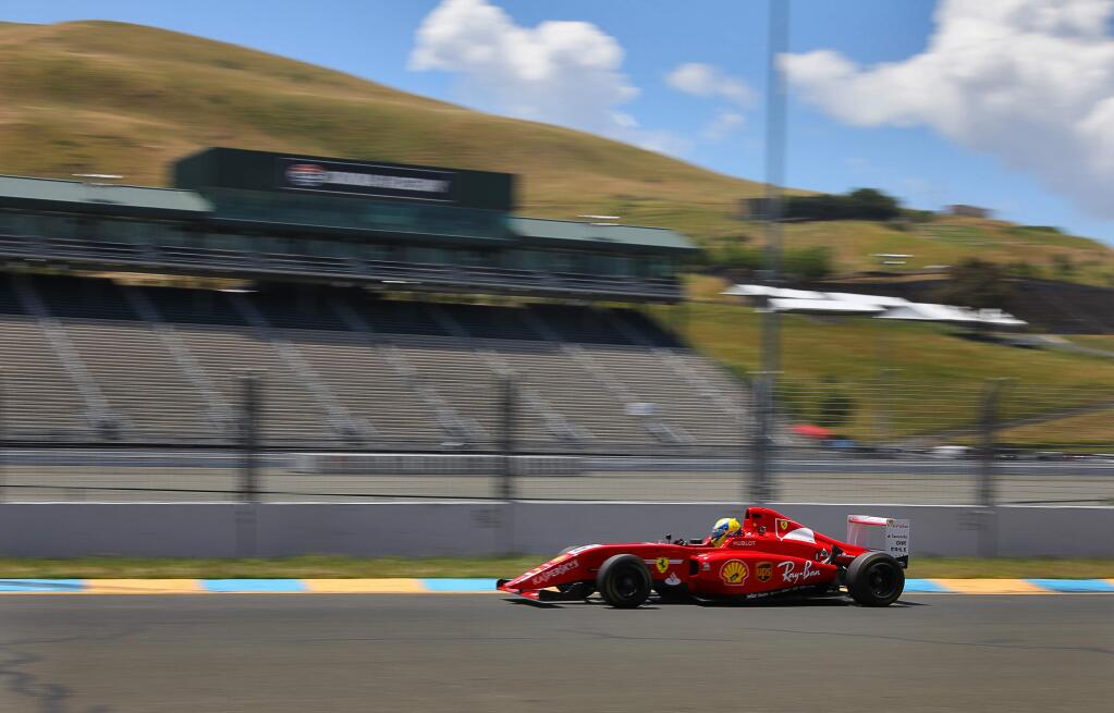 An open-wheel race car speeds past the grandstand at Sonoma Raceway, near Sonoma on Thursday, May 23, 2019. (Christopher Chung/ The Press Democrat)