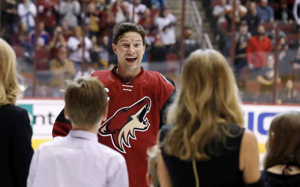 Arizona Coyotes' Shane Doan smiles as he greets his wife and kids as he is recognized for becoming the franchise leader for goals, with his 380th, during ceremonies prior to an NHL hockey game against the San Jose Sharks, Thursday, Jan. 21, 2016, in Glendale, Ariz. (AP Photo/Ross D. Franklin)