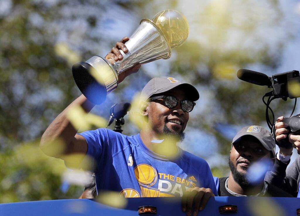 In this June 15, 2017, file photo, Golden State Warriors' Kevin Durant holds the NBA Finals MVP trophy during a parade and rally celebrating the Warriors' NBA championship in Oakland. (AP Photo/Marcio Jose Sanchez, File)
