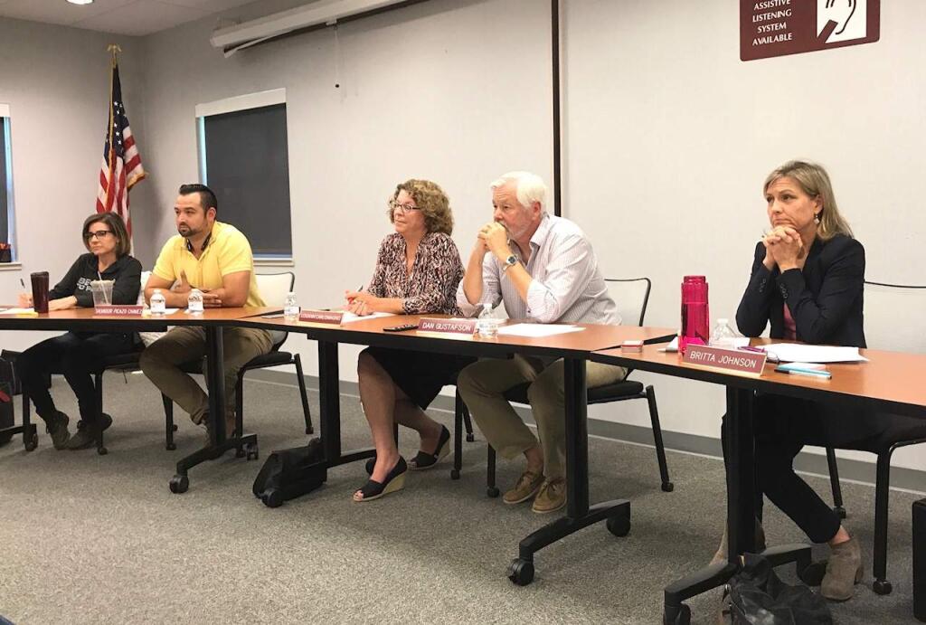 School board trustees listen intently at the hastily called June 10 meeting to map out a short-term direction for the district following the surprise resignation of Superintendent Louann Carlomagno, center.
