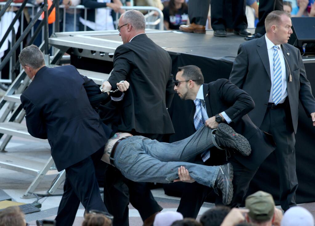 Secret Service agents remove a man from the crowd during a campaign rally for Democratic presidential candidate, Sen. Bernie Sanders, I-Vt., at Frank Ogawa Plaza in Oakland, Calif., on Monday, May 30, 2016. A group of animal rights activists briefly interrupted the Sanders rally in Northern California when they jumped barricades and tried to rush the podium. Sanders' security stopped the protesters before they could reach Sanders, who was addressing supporters at the rally and continued his speech within minutes of the disruption. (Anda Chu/Oakland Tribune via AP)