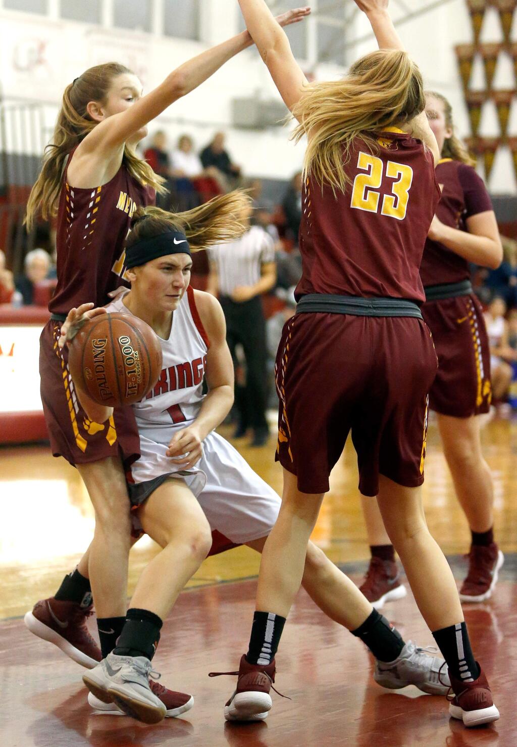 Montgomery's Ciarah Michalik (1), center, dishes a pass back outside between Menlo-Atherton's Linnea Lindblom (11) and Emilie Mueller (23) during the first half of the CIF NorCal Division 2 first round playoff girls basketball game between Menlo-Atherton and Montgomery high schools, in Santa Rosa, California, on Wednesday, March 7, 2018. (Alvin Jornada / The Press Democrat)