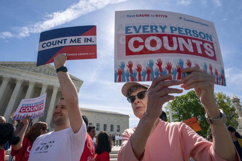 Immigration activists rally outside the Supreme Court on Tuesday as the justices hear arguments over the Trump administration's plan to ask about citizenship on the 2020 census. (J. SCOTT APPLEWHITE / Associated Press)