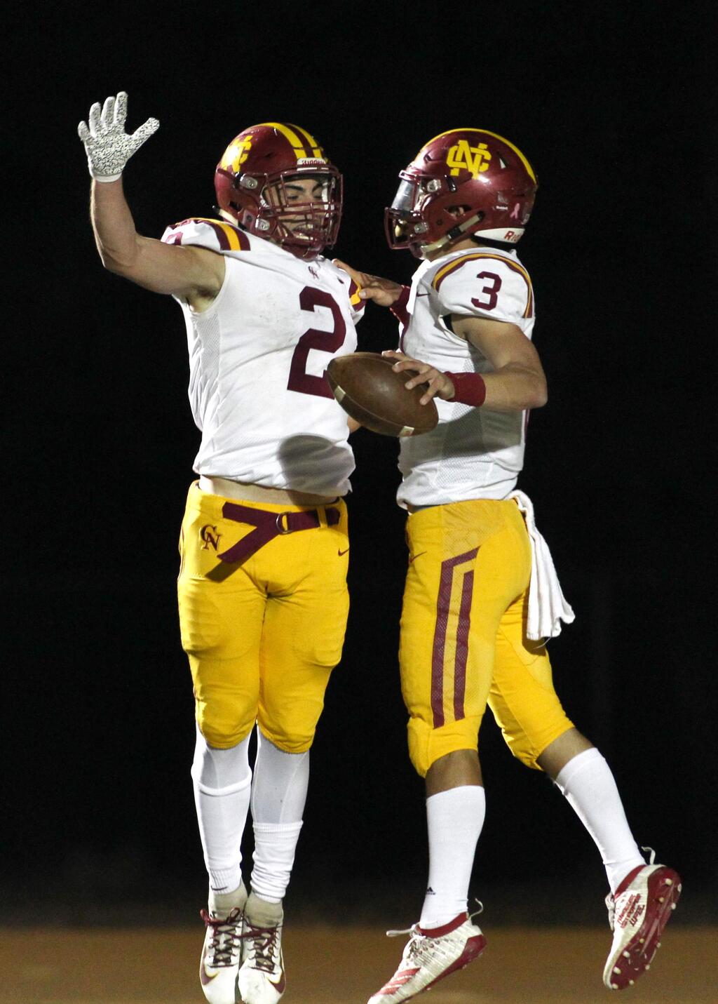 Cardinal Newman's Giancarlo Woods (2) and Jackson Pavitt (3) celebrate a touchdown by Pavitt against Maria Carrillo in Santa Rosa on Monday, Nov. 4, 2019. (Photo by Darryl Bush / For The Press Democrat)
