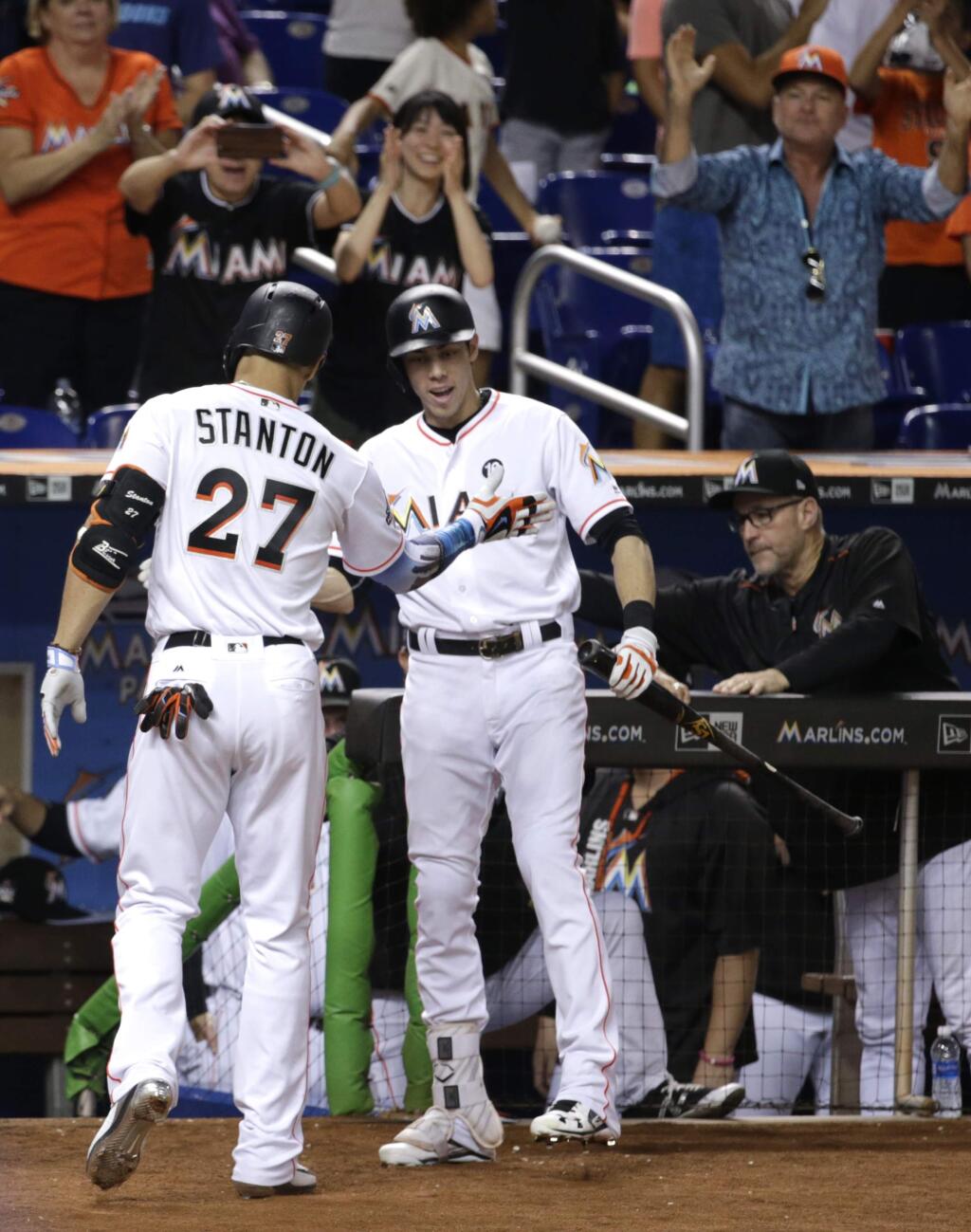 Miami Marlins' Giancarlo Stanton (27) is congratulated by Christian Yelich after hitting a solo home run during the third inning of a baseball game against the San Francisco Giants, Tuesday, Aug. 15, 2017, in Miami. (AP Photo/Lynne Sladky)