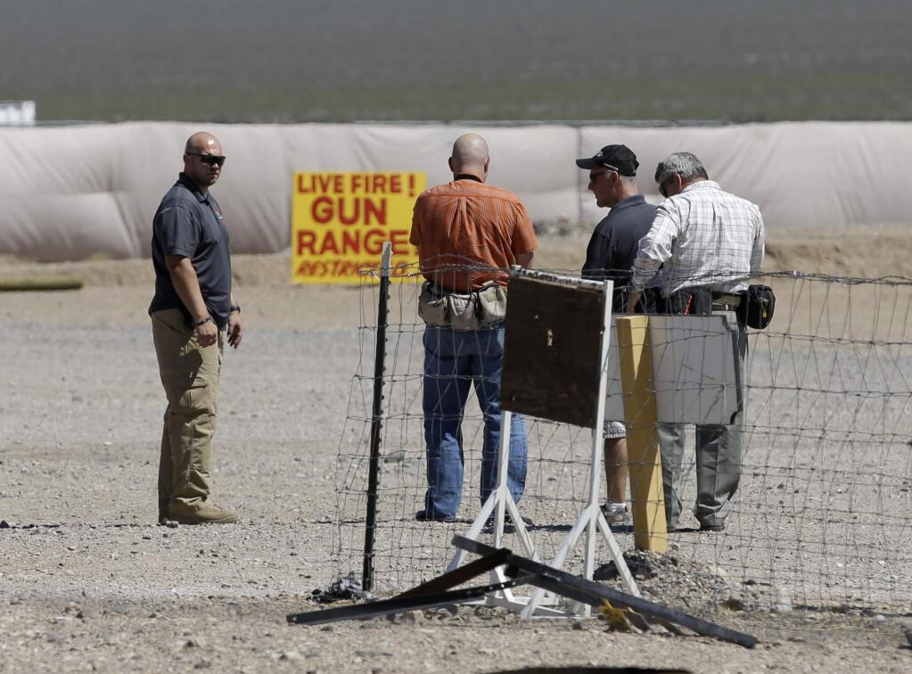 People are seen at the Last Stop outdoor shooting range Wednesday, Aug. 27, 2014, in White Hills, Ariz. Gun range instructor Charles Vacca was accidentally killed Monday, Aug. 25, 2014 at the range by a 9-year-old with an Uzi submachine gun. (AP Photo/John Locher)