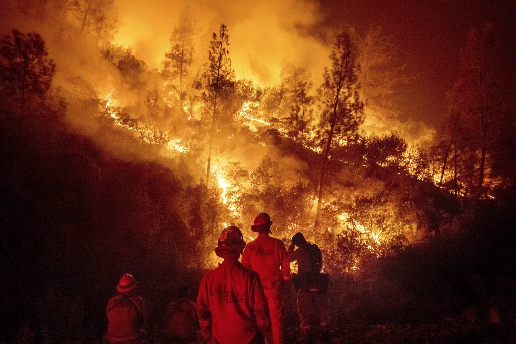 FILE - In this Aug. 7, 2018 file photo, firefighters monitor a backfire while battling the Ranch fire, part of the Mendocino Complex fire near Ladoga, Calif. (AP Photo/Noah Berger)