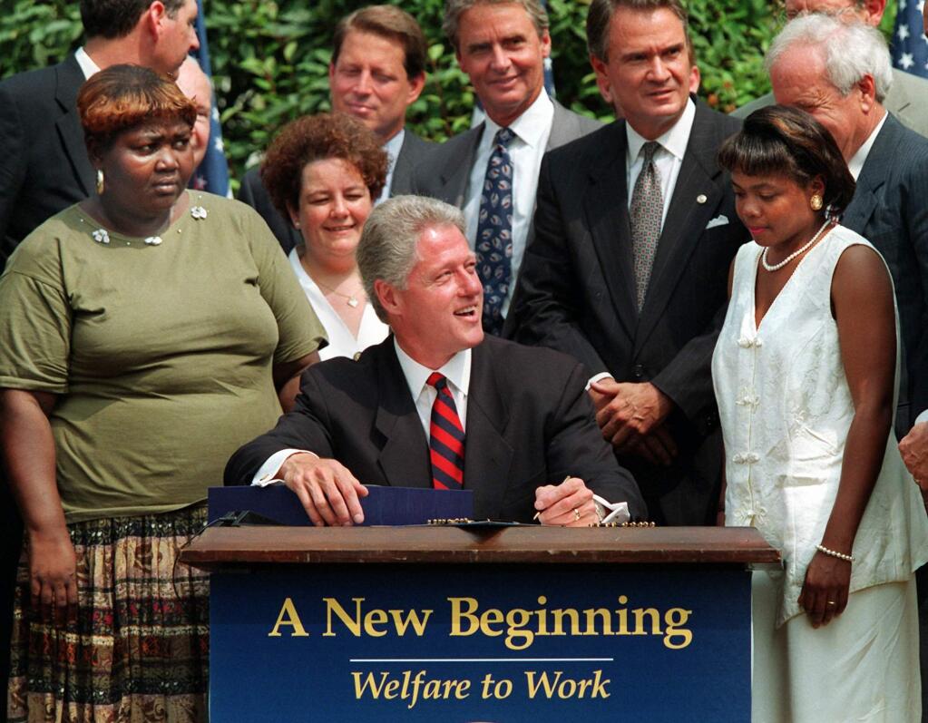 President Bill Clinton prepares to sign welfare reform legislation in the Rose Garden of the White House on Aug. 22, 1996. (J. SCOTT APPLEWHITE / Associated Press)