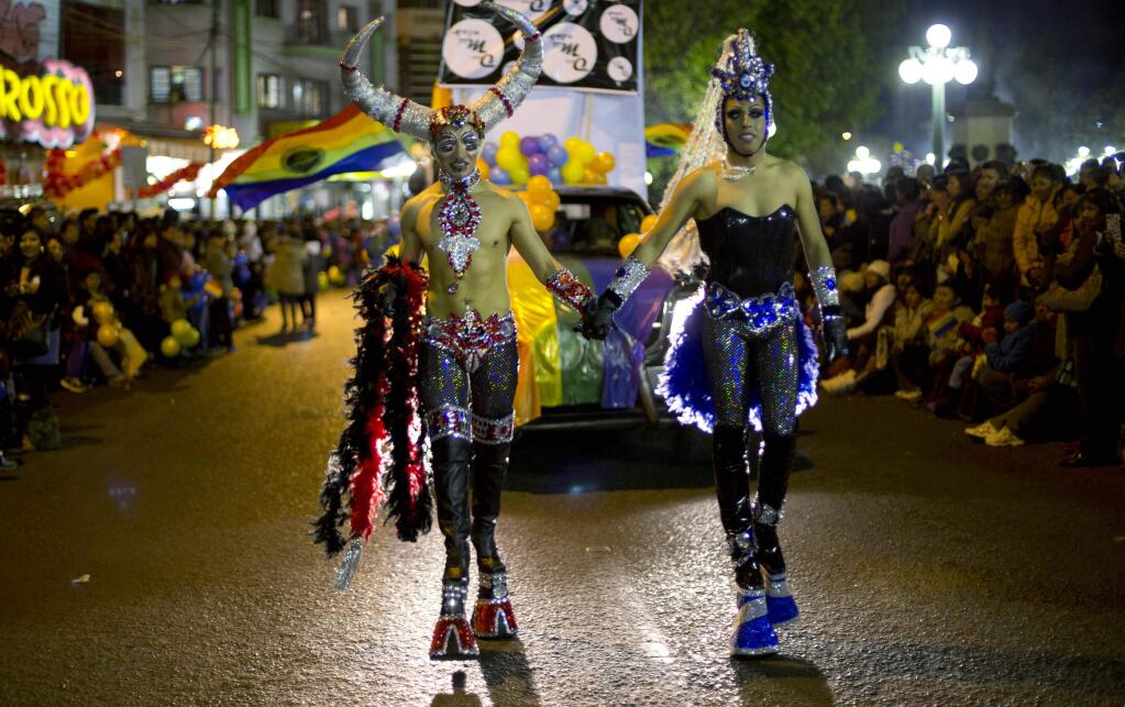Two revelers walk during the annual gay pride parade in La Paz, Bolivia Saturday, June 27, 2015. (AP Photo/Juan Karita)