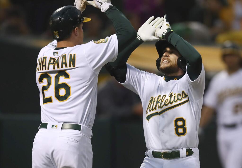 The Oakland Athletics' Jed Lowrie, right, celebrates with Matt Chapman after hitting a two-run home run off the Seattle Mariners' Felix Hernandez in the third inning Tuesday, Aug. 14, 2018, in Oakland. (AP Photo/Ben Margot)