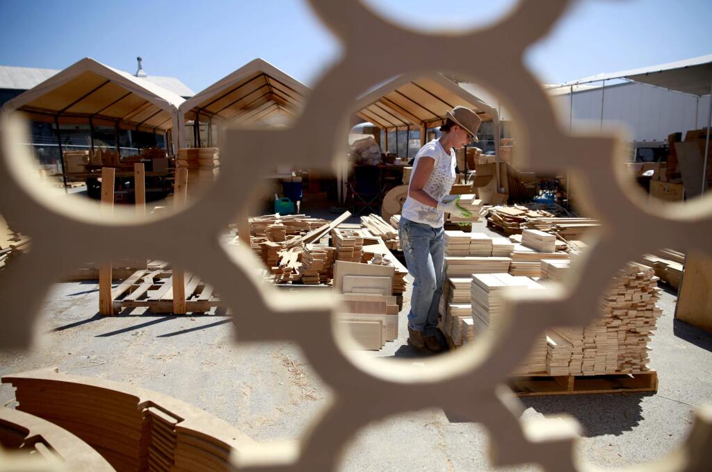 Lisa Bryant stacks up pieces of a wooden temple which will be constructed at Burning Man, on Thursday, July 24, 2014 in Petaluma, California.