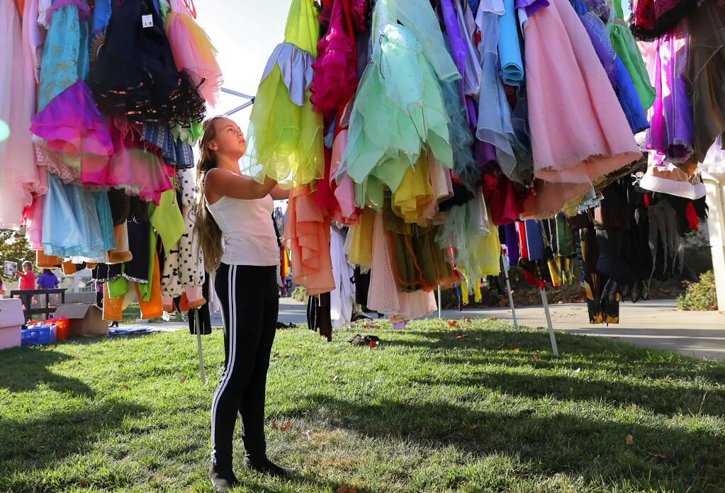 Piner-Olivet Charter School seventh-grader Jaiden Brooner picks out a Halloween costume during an event hosted by the Boys & Girls Club in Santa Rosa on Monday, Oct. 30, 2017. Brooner lost her Sansone Drive home in the Tubbs Fire and is living with a friend.(Christopher Chung/ The Press Democrat)