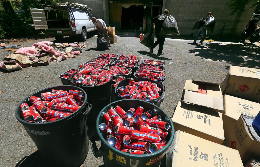 Thousands of butane canisters filled trash cans, boxes and bags outside a Condo Court business after a Tuesday, July 19, 2016, fire led to the discovery of an illegal hash oil processing facility. Santa Rosa Police officers hauled away garbage bags filled with marijuana from the business on Wednesday, July 20, 2016. (JOHN BURGESS/ PD)