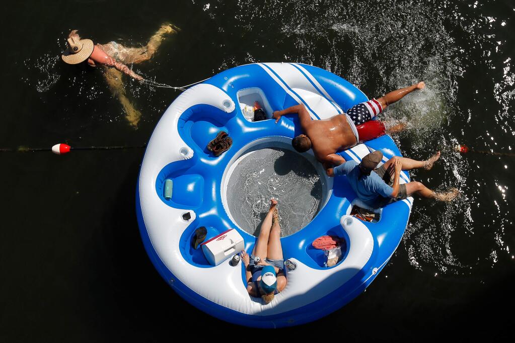 Sweating too much under the blistering sun? Feeling like you just can't beat the heat? Don't let hot weather confine you to your house! Explore the North Bay with these 10 fun ideas to stay cool this summer. In this photo, Jen Heskett, Aaron Gonzales, Jim Ship and Brittany Ship float in Russian River at Veterans Memorial Beach in Healdsburg in 2017. (ALVIN JORNADA/ PD)