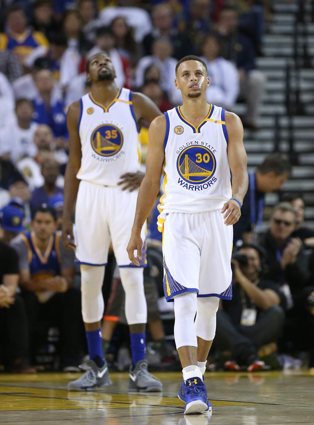 Golden State Warriors Stephen Curry and Kevin Durant glance up at the scoreboard as they fall behind the San Antonio Spurs, during their game in Oakland on Tuesday, October 25, 2016. (Christopher Chung/ The Press Democrat)