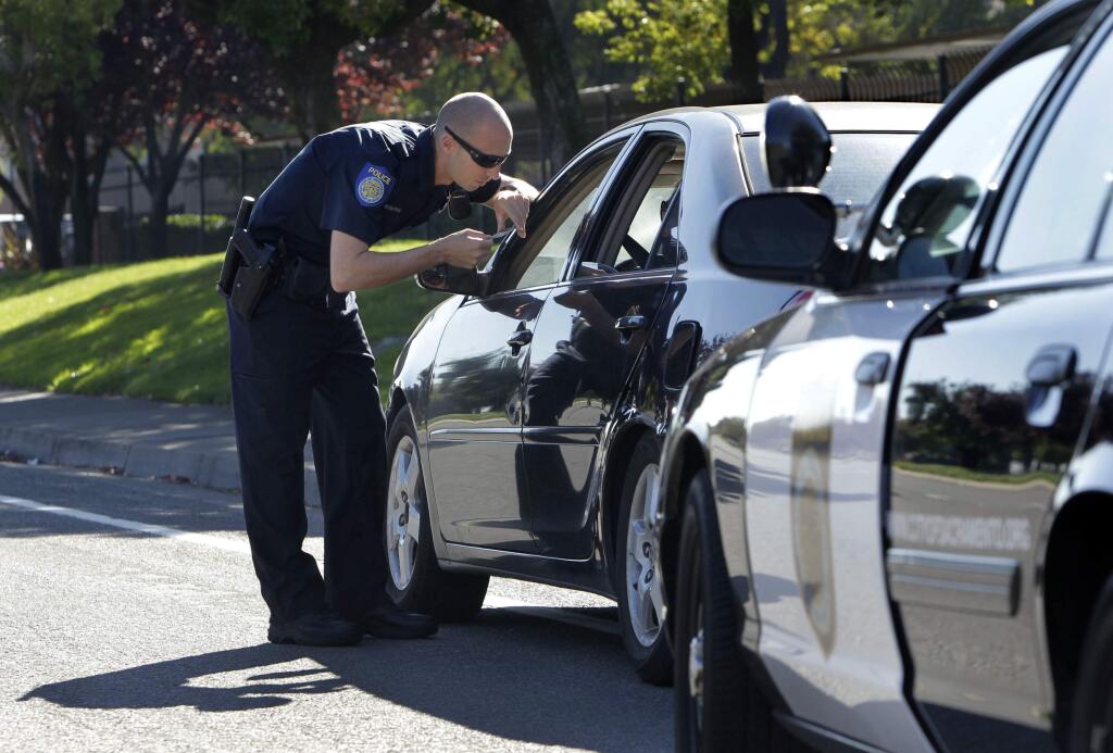 FILE - In this Nov. 12, 2012 file photo, a Sacramento Police Officer makes a traffic stop in Sacramento, Calif. (AP Photo/Rich Pedroncelli, File)