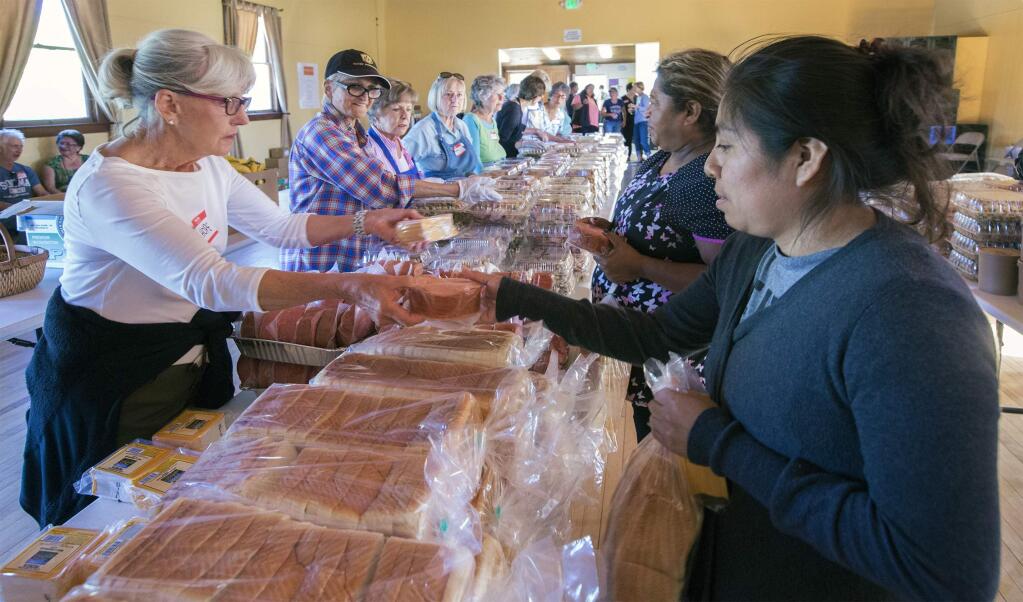 At the Springs Community Meeting Room (formerly The Grange) on Monday, Oct. 23, food is organized, volunteers prepare and community members arrive to partake in the effort to feed anyone who needs feeding. (Photo by Robbi Pengelly/Index-Tribune)