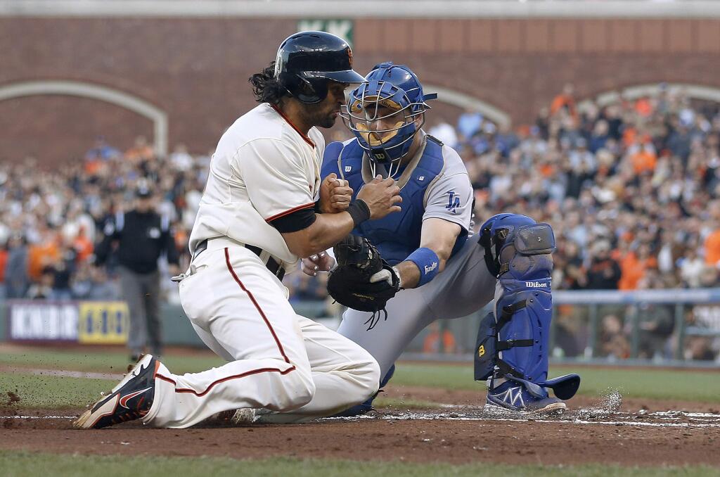 Los Angeles Dodgers catcher A.J. Ellis, right, tags out San Francisco Giants' Angel Pagan at home plate during the first inning of a baseball game Saturday, Sept. 13, 2014, in San Francisco. (AP Photo/Tony Avelar)