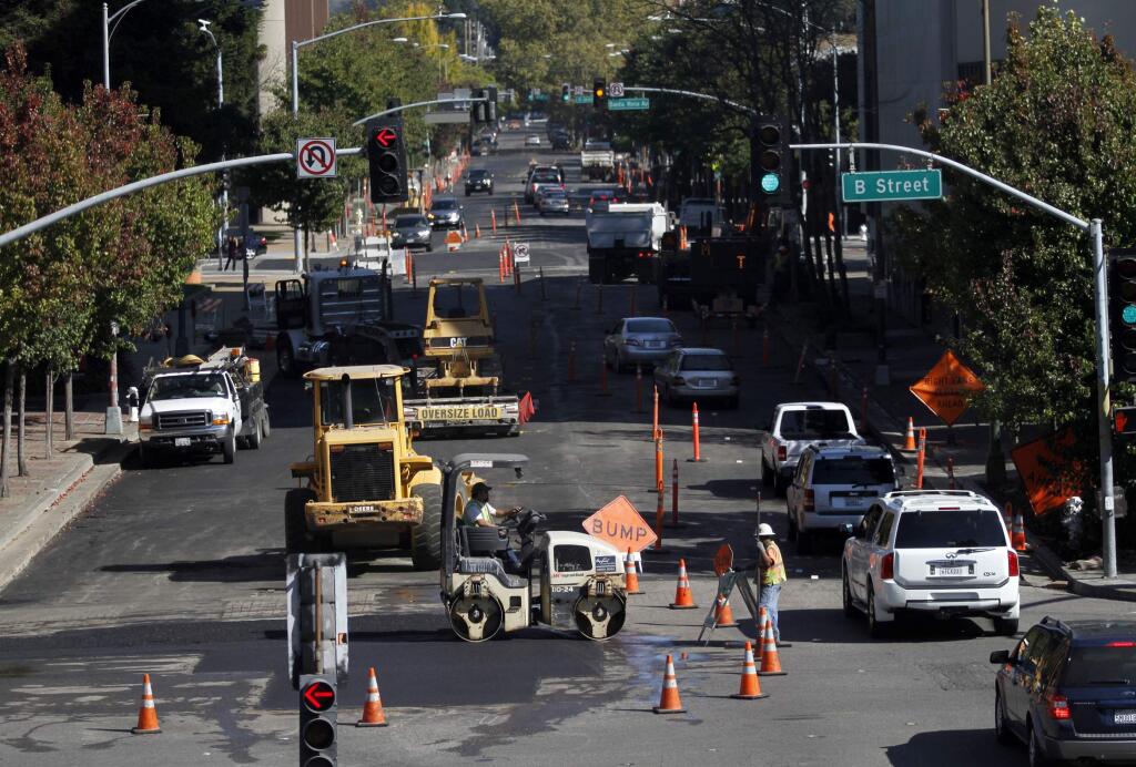 Workers smooth asphalt as they perform road repairs along Third and B streets in Santa Rosa, California. (Beth Schlanker / The Press Democrat) File